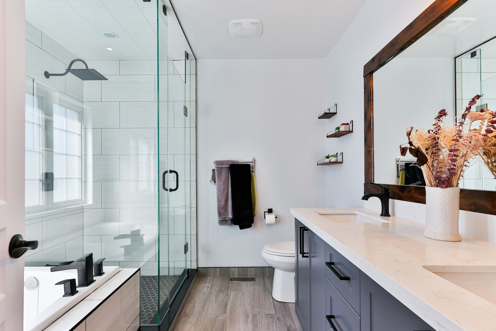 Finished bathroom remodel with glass shower, dual vanity, and dark cabinetry