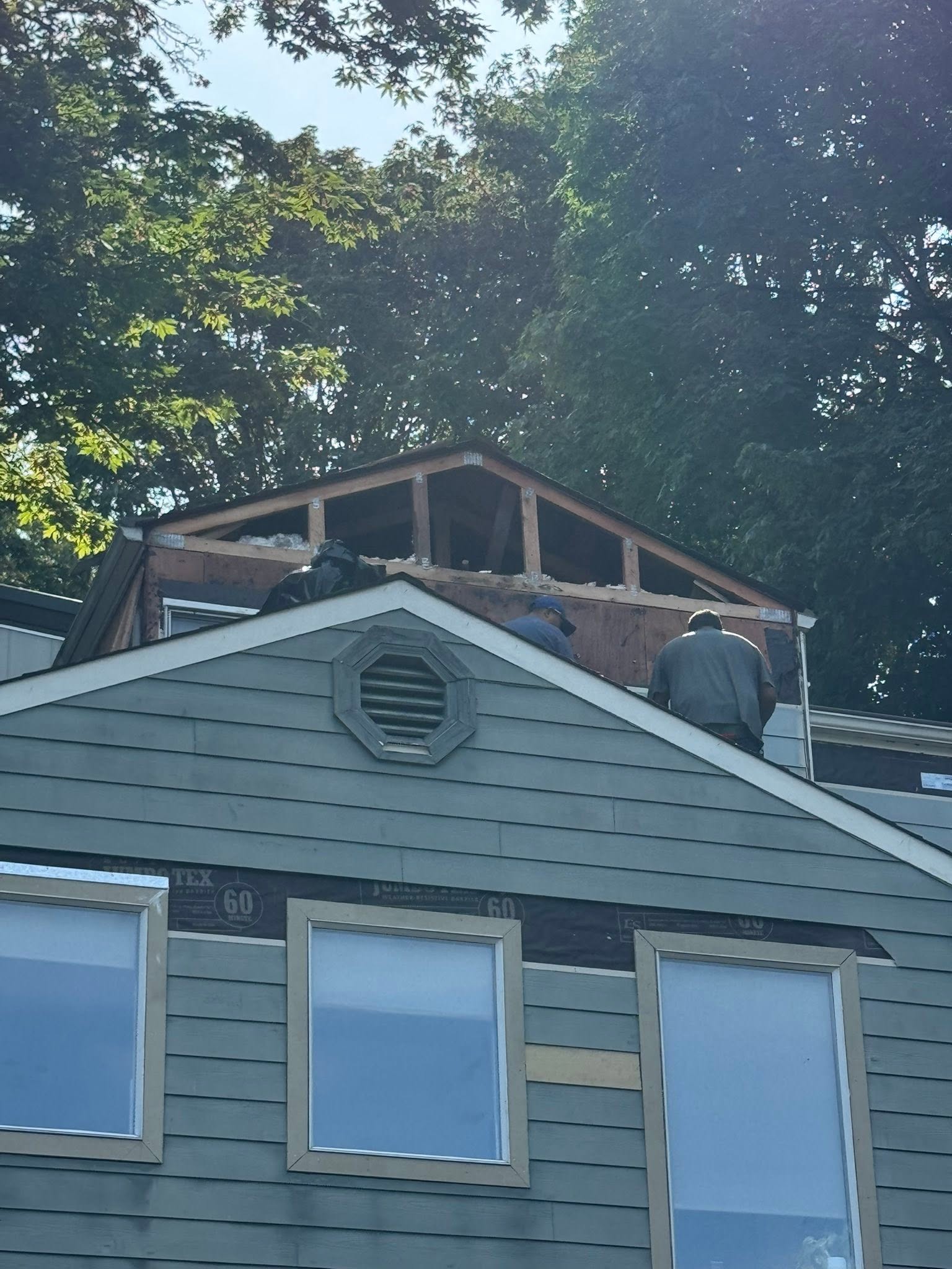 All In One Construction crew working on roof framing and siding at a King County home